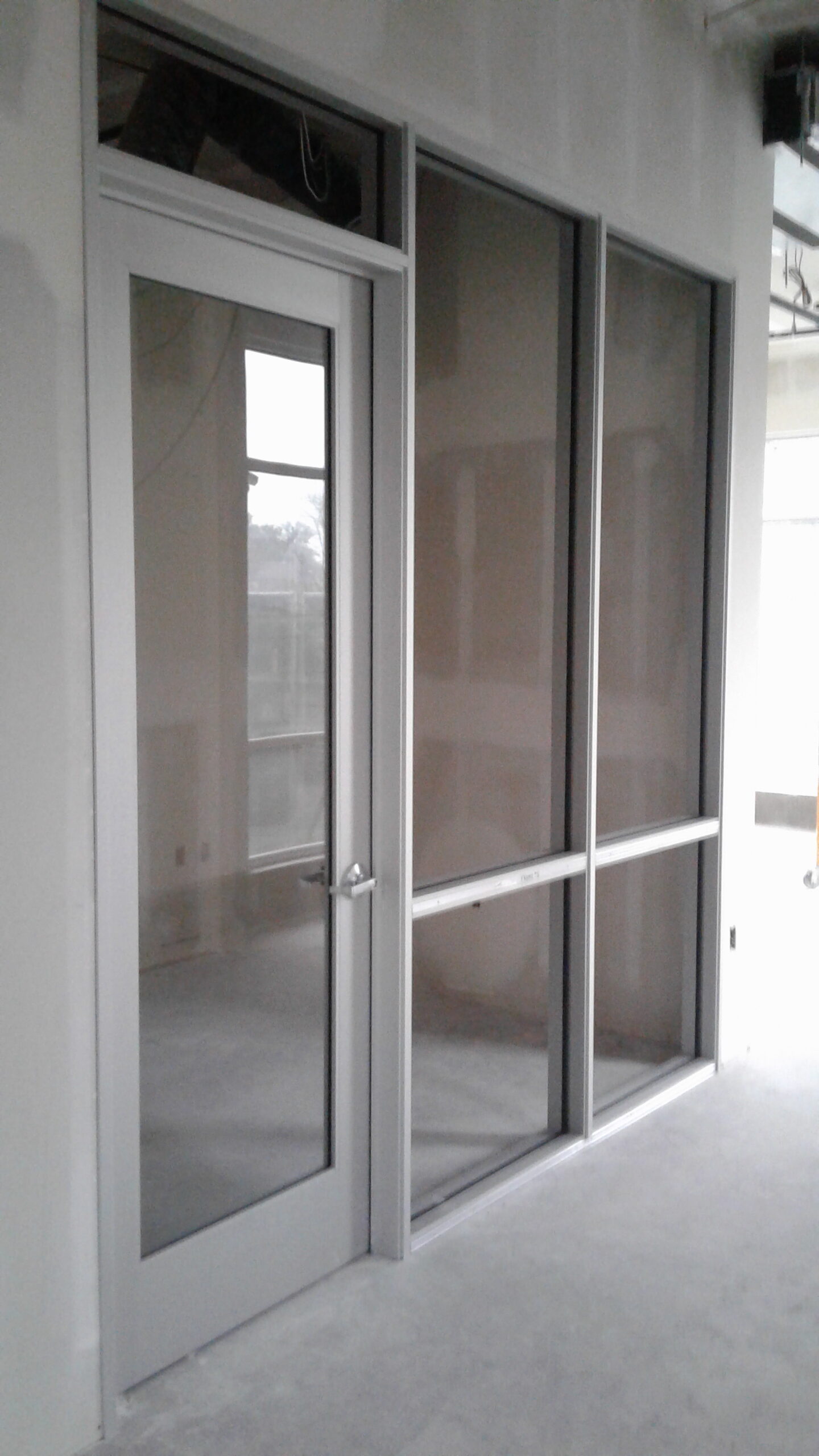 Aluminum storefront framing with door lite installed during commercial construction