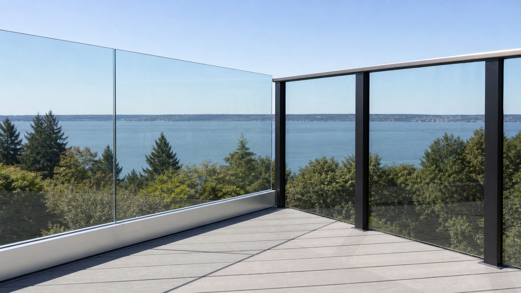 Frameless glass railing with no top rail meeting a post-supported section with a continuous cap rail at a deck corner